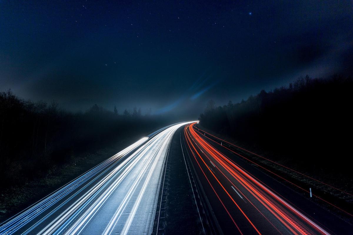 Autopista por la noche con tráfico en las dos direcciones
